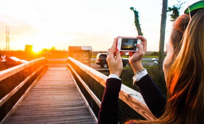 A girl taking pictures with her smartphone. 